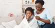 © Prostock-studio - Flu Concept. Worried black mother checking her daughter's temperature, child covered in blanket, copy space