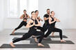 © New Africa - Group of people practicing yoga on mats in class
