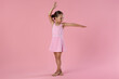 © New Africa - Little ballerina practicing dance moves on pink background