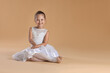 © New Africa - Portrait of little ballerina on beige background, space for text