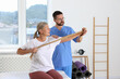 © New Africa - Senior patient exercising under physiotherapist supervision in rehabilitation center