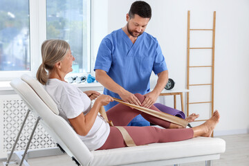 Canvas Print - Physiotherapist working with senior patient in rehabilitation center