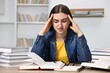 © New Africa - Tired student before exam at table among books indoors