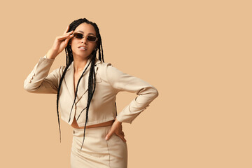 Wall Mural - Stylish African-American woman with braids on beige background