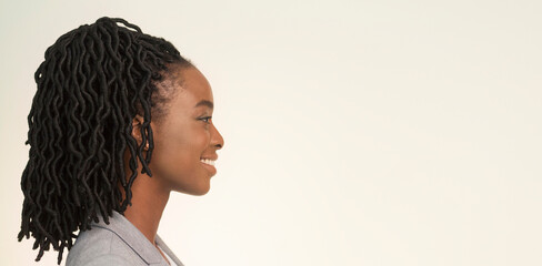 Poster - Portrait Of Smiling African American Businesswoman Looking Aside On White Background In Studio. Side View, Panorama, Empty Space