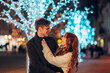 © Zamrznuti tonovi - Festive loving couple hugging and celebrating new year on a street.