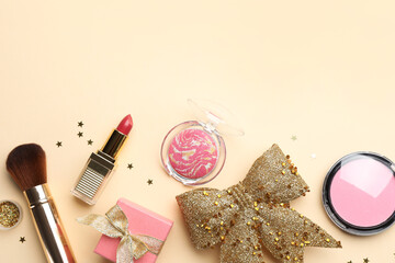 Poster - Flat lay composition with makeup products and Christmas decor on beige background. Space for text