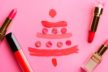 Poster - Christmas tree drawn with lipsticks on pink background, flat lay