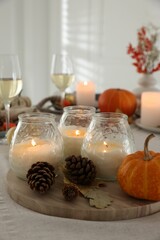 Poster - Burning candles and autumn decor on table indoors