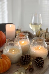 Canvas Print - Burning candles and autumn decor on table, closeup