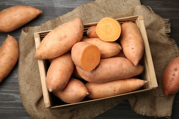 Poster - Fresh raw sweet potatoes in crate on wooden table, top view