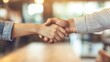© Achira22 - Two business professionals shake hands in a formal setting, symbolizing agreement, partnership, or successful negotiation.