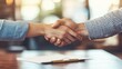 © Achira22 - Two business professionals shake hands in a formal setting, symbolizing agreement, partnership, or successful negotiation.
