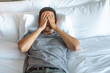 © kieferpix - Tired, stressed exhausted man lying in bed hand over face