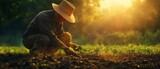 Inspiring image of a farmer in a sun hat planting seeds in lush soil, highlighting the importance of agriculture and environmentallyfriendly farming