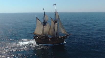 A sailing ship navigating through calm ocean waters.