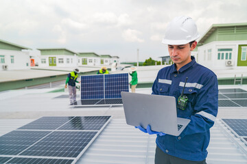Wall Mural - a worker in protective gear uses a laptop while inspecting solar panels on a rooftop. the image emph