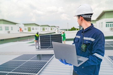 Wall Mural - a worker in protective gear uses a laptop while inspecting solar panels on a rooftop. the image emph