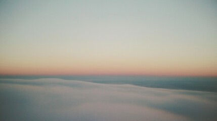 a vast expanse of sky stretches out with a soft gradient from pale blue at the horizon to a deep, rich indigo at its zenith