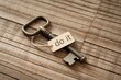 © K-MookPan - Vintage key with a tag saying 'do it', placed on wooden background.