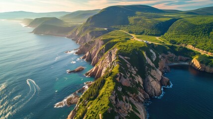 A beautiful view of the ocean and mountains. The sky is clear and the sun is shining. The water is calm and the mountains are covered in green trees