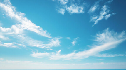 clear blue sky with soft, wispy clouds drifting across, evoking a sense of peace, freedom, and open 