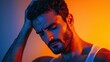 © Adul khotchasri - A moody portrait of a man with wet skin, bathed in vibrant blue and orange lighting, conveying deep emotion and introspection.