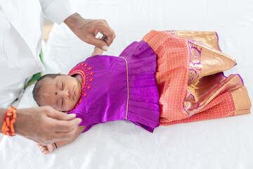 ndian family spending time together, wearing traditional and casual outfits with a baby, a young girl, and grandparents in a high-rise apartment in Kuala Lumpur, Malaysia.