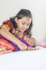 ndian family spending time together, wearing traditional and casual outfits with a baby, a young girl, and grandparents in a high-rise apartment in Kuala Lumpur, Malaysia.