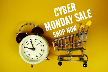 Cyber Monday Sale text with alarm clock and trolley shopping cart on yellow background