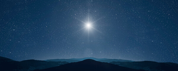 Wall Mural - a christmas star shines at night over the mountains of bethlehem