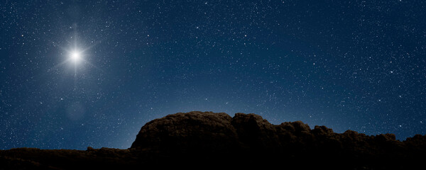 a Christmas star shines at night over the mountains of Bethlehem