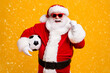 © deagreez - Portrait of his he nice attractive cheerful cheery Santa holding in hands ball celebrating having fun win winner luck attainment isolated over bright vivid shine vibrant yellow color background