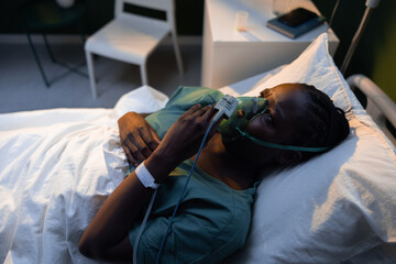 Post-surgery, the patient rests in her hospital room, relying on an oxygen mask for a smooth recovery.