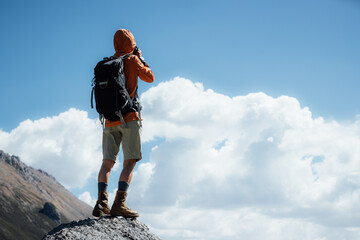 Poster - Woman photographer taking picture on high altitude mountain top,with a lake in the distance