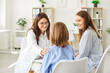 © Studio Romantic - Female friendly doctor talking with a child patient during medical examination sitting in clinic with mother. Pediatrician woman support young girl and giving consultation in exam room.
