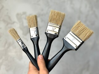 paint brushes in hand on a light background