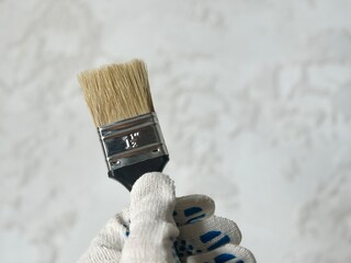 paint brush in hand on a blurred background close-up.