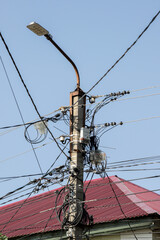 A pole with a light on top and wires coming out of it