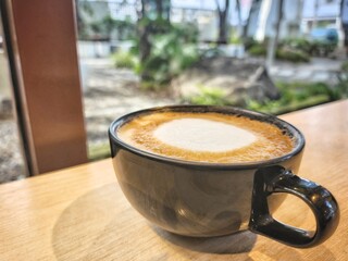 Coffee latte art milk foam on wood table background