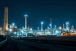 © CorelZavr - Panoramic night view of an electric power station with bright lights illuminating its towers, pipes, and machinery. The dark, starry sky adds depth to the scene.