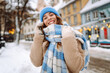© maxbelchenko - Smiling woman walking in street in winter outfit wearing checkered scarf,coat,  knitted hat. Happy mood. Fashion style trend. Winter holidays.
