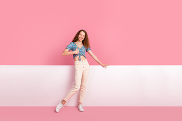 Wall Mural - Smiling woman posing against bright pink and white background