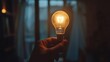 © Darunee - Close-up of a person's hand turning on a lightbulb in a dark room, with a focus on the moment of illumination and inspiration