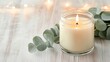 © Paul - A minimalist setting with a burning aromatic candle in a glass jar, a eucalyptus branch elegantly laid next to it on a rustic wooden table, soft natural light