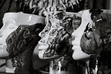 Poster - A collection of ceramic heads lined up on display, black and white photograph.