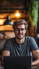 Poster - Smiling Young Man with Glasses Working on Laptop in Cafe. Remote Work, Freelancing Concept.