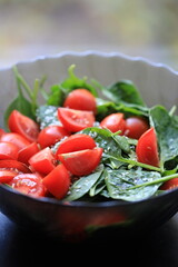Poster - Fresh spinach and tomatoes arranged on a table, perfect for a healthy snack or salad.