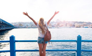 Happy young girl traveler with backpack enjoying view of Istanbul cityscape, Turkey