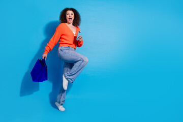 Photo portrait of wavy haired model woman using smartphone order gifts online running buying more isolated on blue color background